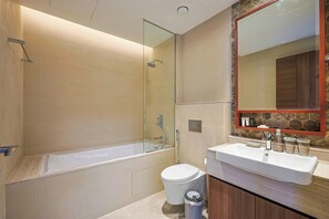 Ein modernes Badezimmer mit Badewanne, Toilette und Waschbecken.