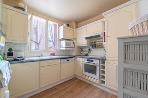 Eine Küche mit weißen Schränken, einer integrierten Mikrowelle und einem Backofen.