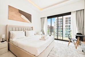 A hotel room with a large bed, a desk, and a view of a cityscape through floor-to-ceiling windows. - Azizi 63 Studio · Pool & Gym · Meydan (Dubai)