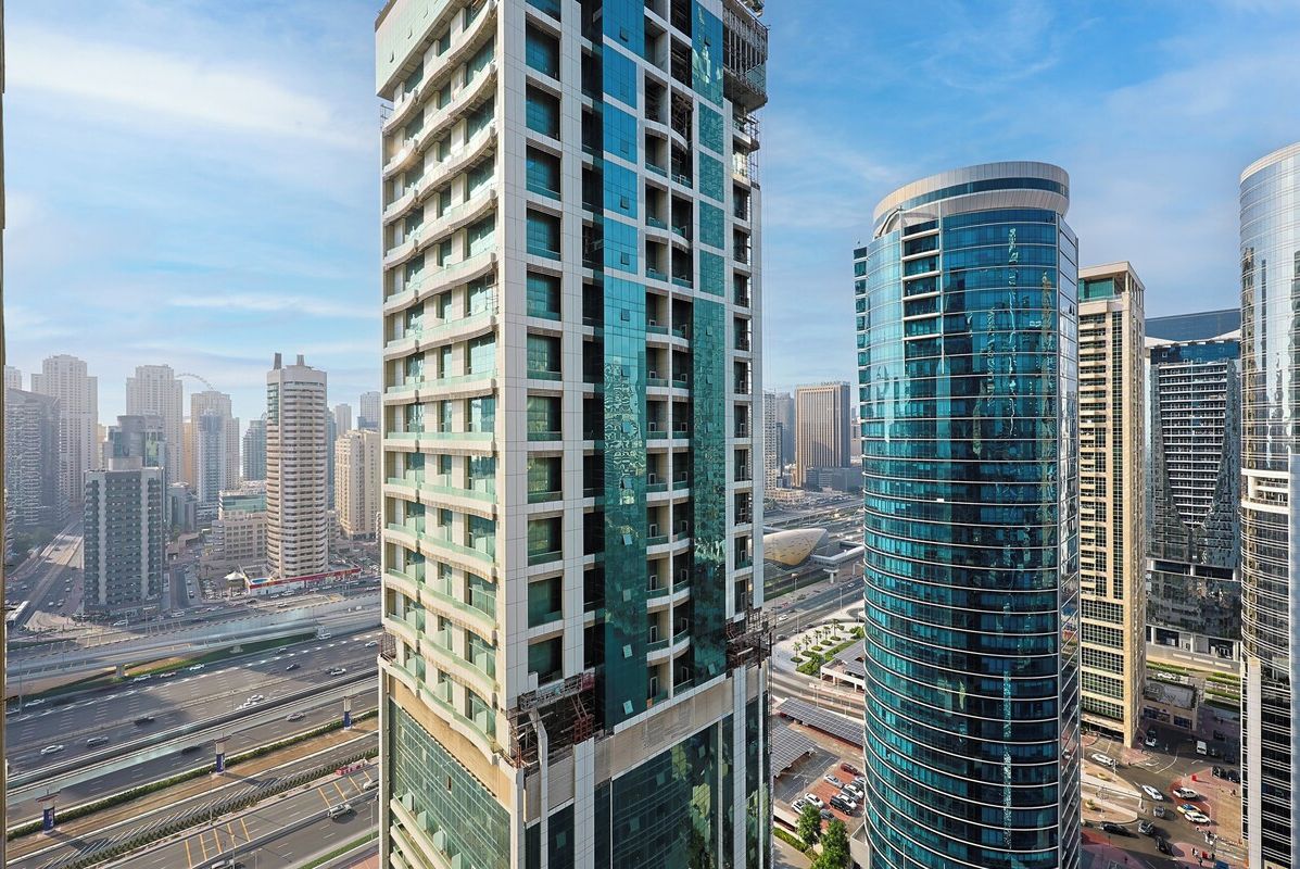 A high-rise building with a modern design, featuring multiple floors and a curved glass facade.