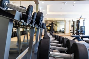 A row of dumbbells on a rack in a gym with mirrors on the wall. - Riviera 42 Studio · Lagoon Resort · Meydan (Dubai)