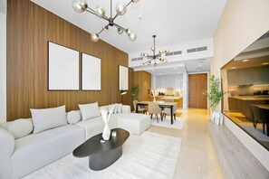 A modern living room with a sofa, coffee table, and artwork on the wall. - Imperial 2BR · Burj View · Downtown (Dubai)