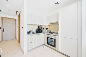 Eine moderne Küche mit weißen Schränken, einem eingebauten Backofen und einem Gasherd.