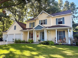 A two-story house with a front porch, a garage, and a well-maintained lawn. - ND Game Day Retreat, Sleeps 11, Grill & Pool Table (Granger)