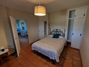 A bedroom with a bed, a wardrobe, and a door leading to another room. - Hierbabuena Apartment – Perfect for Families (Vejer de la Frontera)