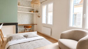 A bedroom with a bed, a chair, a desk, and a window. - Harmoni Studio (Chartres)