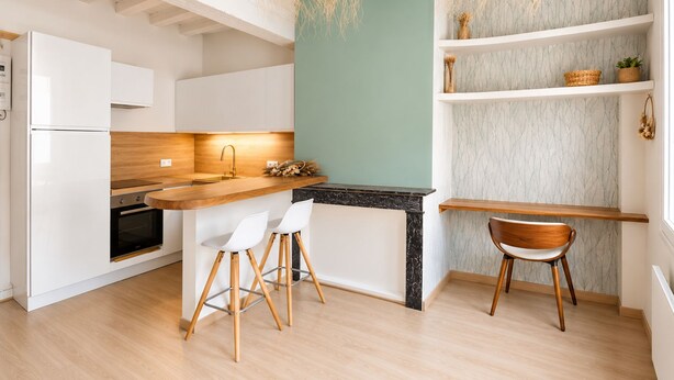 A modern kitchen with white cabinetry, a wooden countertop, and a black backsplash. There are two white chairs and a wooden stool. - Harmoni Studio (Chartres)