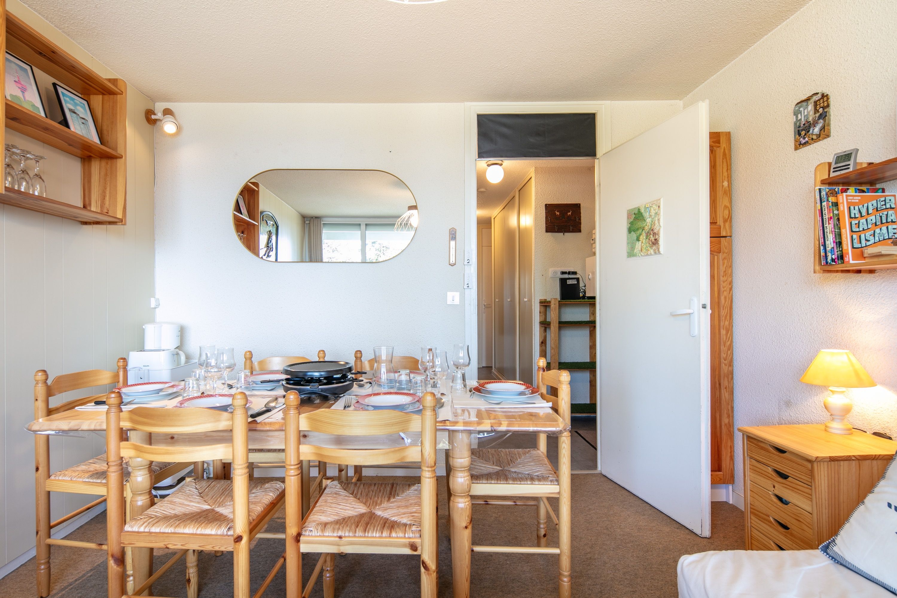 Een eetgedeelte met een tafel gedekt voor vier personen, omringd door houten stoelen met geweven zitplaatsen.