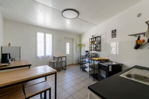 Eine kleine Küche mit Spüle, Herd und einer Essecke mit Hocker.