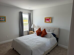 A bedroom with a bed, a nightstand, a lamp, and two framed pictures on the wall. - 3-bedroom Clemson house in Seneca minutes from school (Seneca)