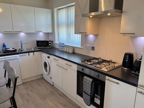A modern kitchen with a gas stove, microwave, and built-in oven.