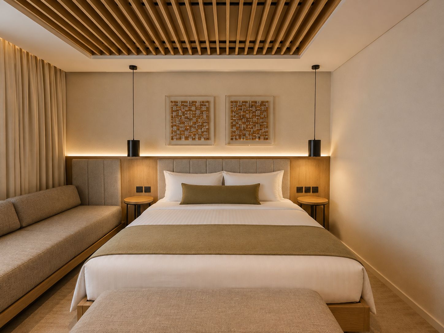 Une chambre d’hôtel moderne avec un grand lit, un canapé, deux tables de chevet et un plafond avec des lambris en bois.