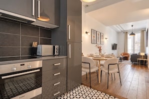 A modern kitchen with a Bosch oven, a microwave, and a refrigerator. - Charming Apartment Montaigne Champs Elysees (Paris)