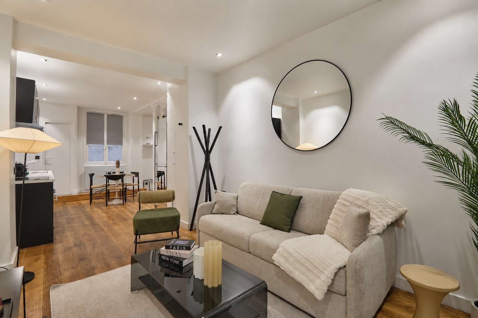 Una sala de estar moderna con un sofá, una mesa de centro y un comedor al fondo.