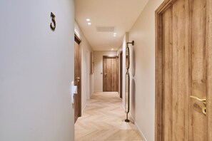 Ein Korridor mit Holztüren, einem Schild mit der Nummer 3 und einem Spiegel an der Wand.