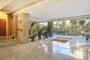 A modern lobby with a marble floor, a staircase, and potted plants. - Sublim Apartment AC St Germain Luxembourg Park (Paris)