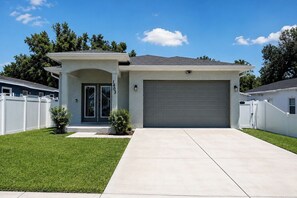 A modern two-story house with a garage, a well-maintained lawn, and a clear blue sky. - Your Tampa Home Away From Home. 3BR/2BA (Tampa)