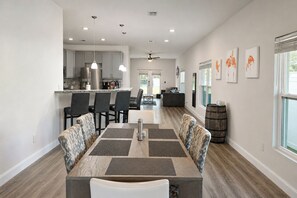 A modern kitchen with a central island, dining area with patterned chairs, and artwork on the walls. - Your Tampa Home Away From Home. 3BR/2BA (Tampa)