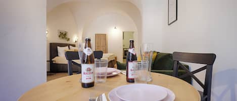 Una mesa de comedor con platos, cubiertos y dos botellas de cerveza.