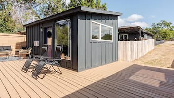 Estructura compacta al aire libre con terraza, zona de estar y una ventana.