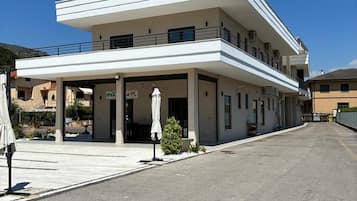 Un bâtiment à deux étages, doté d’un toit plat, d’un espace d’entrée abrité et d’un petit jardin.