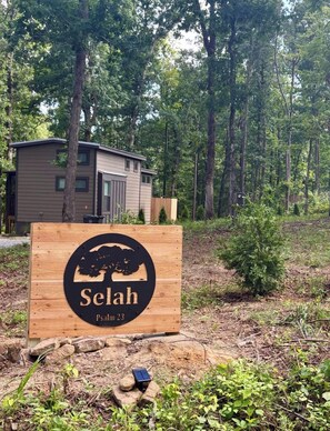 Cartell amb el nom 'Selah' i referència al Salm 23, en un entorn forestal natural.
