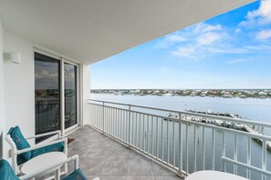Ein Balkon mit Blick auf einen Yachthafen und die Küste in der Ferne.