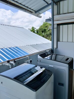 A laundry room with industrial-style washing machines and a metal roof.