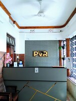 Una recepción con un cartel de PVR, un ventilador de techo y una ventana con vistas.
