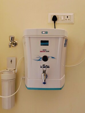A water dispenser with a control panel, a faucet, and a water filter unit.