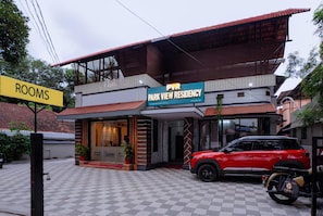 A building with a sign for 'PARK VIEW RESIDENCY' and a 'ROOMS' sign.