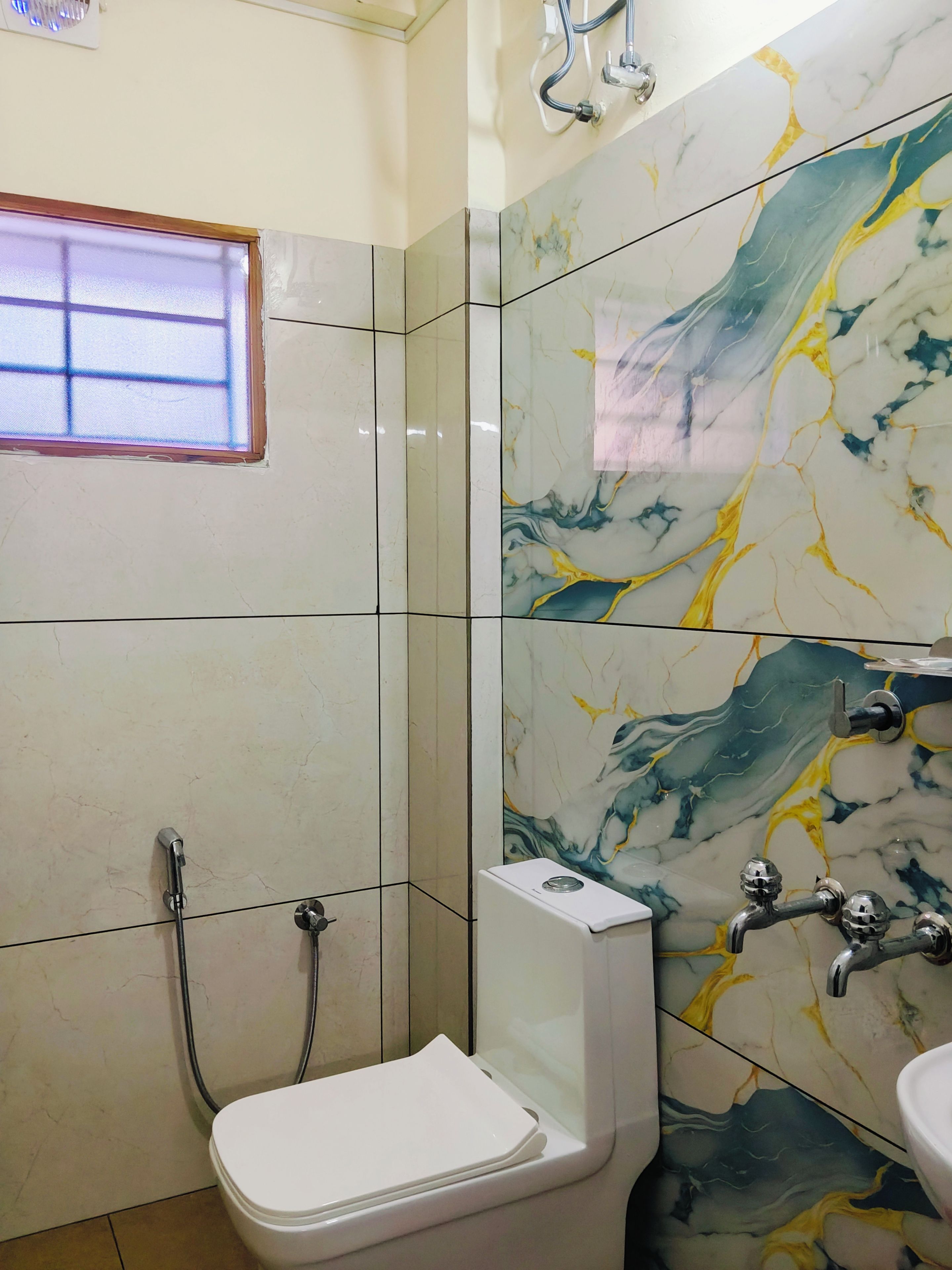 A bathroom with a toilet, a shower, and a sink.