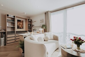 A modern living room with a sofa, a coffee table, and a bookshelf. - Saturn Studio by Navie Stays (Poole)