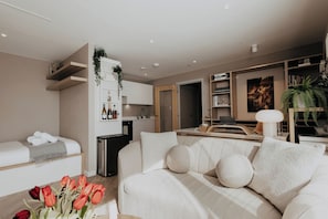 Ein modernes Wohnzimmer mit einer Couch, einem Essbereich und einer Küche.