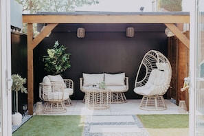 A covered outdoor seating area with wicker furniture and a potted plant. - Coastal Hideaway by Lil Blu Stays (Bournemouth, Christchurch and Poole)