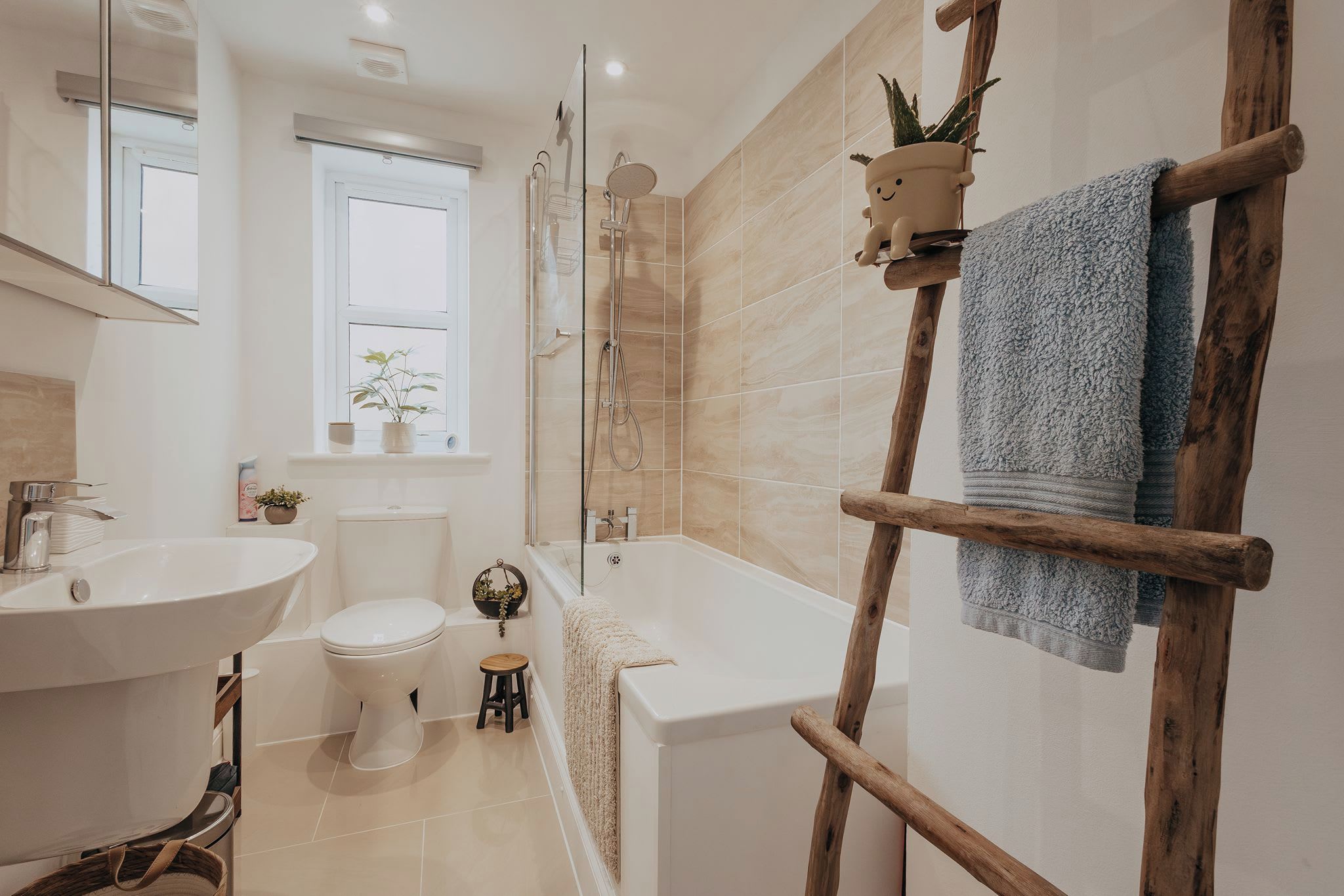 A modern bathroom with a bathtub, shower, toilet, and sink.
