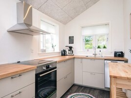 A modern kitchen with a built-in oven, a coffee maker, and a dishwasher.