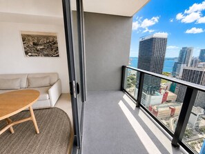 A balcony with a city view, a sofa, and a table. - 38th Floor 1 Bedroom Apartment with balcony & bay views in Downton Miami (Miami)