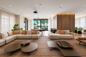 A modern living room with a sectional sofa, a coffee table, and a dining area with a view of the outdoors. - 38th Floor 1 Bedroom Apartment with balcony & bay views in Downton Miami (Miami)