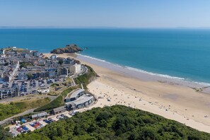 A coastal town with a beach, a parking area, and a prominent building with a curved roof. - 1 Bedford House - Close to Town and Seafront (Tenby)