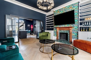 A modern living room with a fireplace, a television, and a bar area. - 2 Bedford House - Close to Town and Seafront (Tenby)