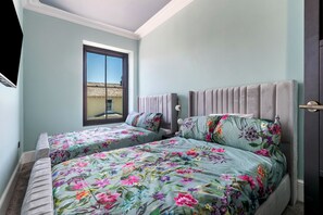 Ein Schlafzimmer mit zwei Betten, einem Fenster und einer Tür.