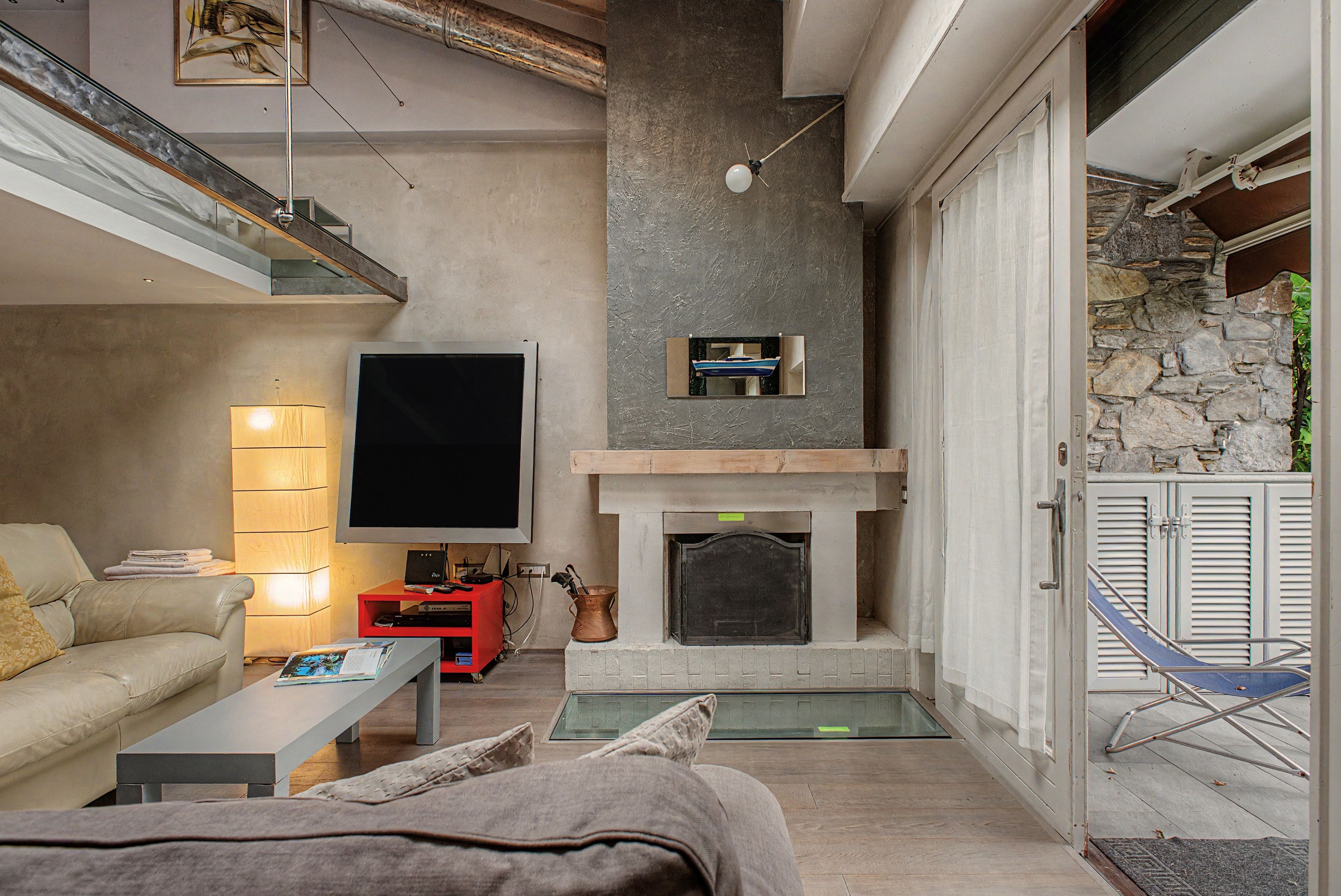 Un salon moderne avec une cheminée, un téléviseur à écran plat et un canapé.
