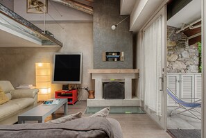 Un salon moderne avec une cheminée, un téléviseur à écran plat et un canapé.