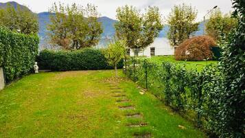 Un jardin bien entretenu, avec un chemin bien défini, une végétation luxuriante et une vue sur les montagnes en arrière-plan.