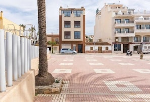 A multi-story residential building with a central courtyard, a palm tree, and a parked car. - Mar Y Sol Caleta, Mar Y Sol Puerto -1A (Algarrobo-Costa)