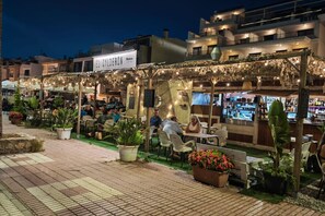 Un espace extérieur aménagé avec des tables et des chaises, un bar et des plantes en pot.
