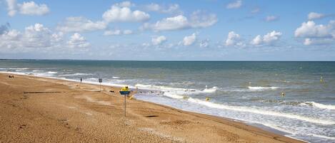 Une plage avec un panneau indiquant l’emplacement d’un poste de sauveteurs.