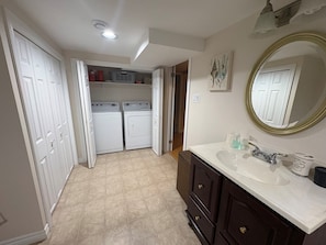 A bathroom with a white sink, dark wooden vanity, and a large mirror.