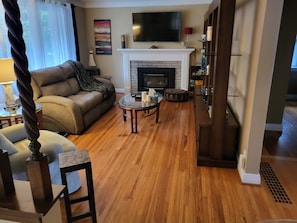 A living room with a fireplace, a sofa, a coffee table, and a television.